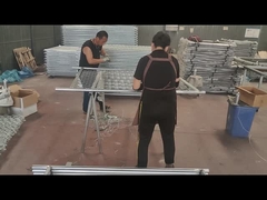 Pekerja menggunakan kawat untuk menghubungkan pagar rantai dan tabung rangka